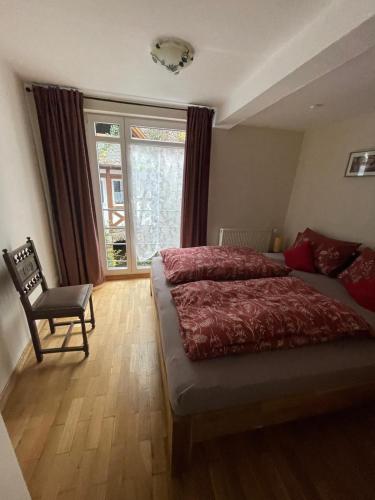 a bedroom with a bed and a chair and a window at Ad Monte in Cochem