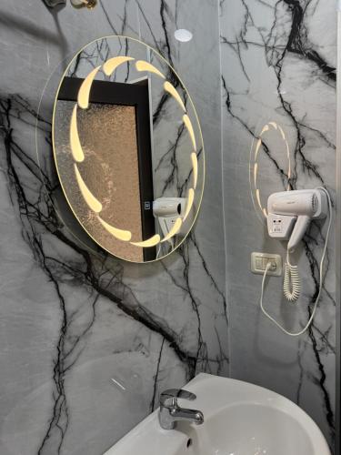 a bathroom with a mirror and a white sink at Heming-way Hotel in Durrës
