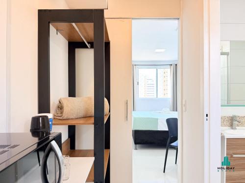 a small room with a bed and a desk and a table at Brisa do Mar Residence by Holiday Stays in Fortaleza