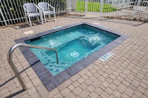 a small swimming pool with two chairs at Tortuga Bay home in South Padre Island