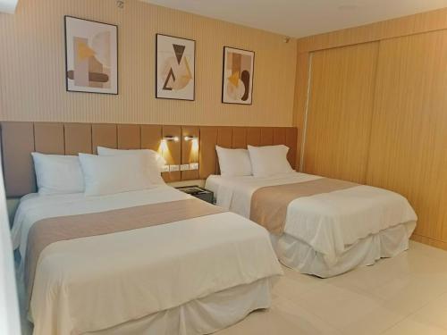 a hotel room with two beds in a room at Baba Staytion 1-2-3 of SMDC Style Condo in Iloilo City