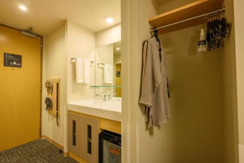 a bathroom with a sink and a mirror at Dormy Inn Premium Ginza - Natural Hot Spring in Tokyo