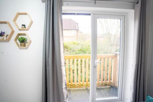 a sliding glass door with a view of a balcony at Modern Luxurious Apartment with Balcony in Shenley Church End