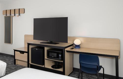 a room with a desk with a tv and a chair at City Express by Marriott Bemidji in Bemidji