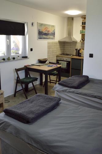 a room with two beds and a table and a kitchen at MM Studio in Donji Miholjac
