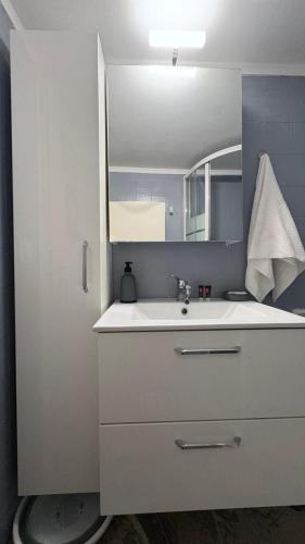 a bathroom with a white sink and a mirror at sunwave Tolo in Tolo