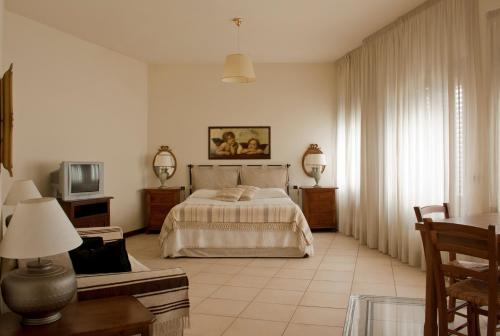 a bedroom with a bed and a couch and a tv at Residence Montefiore in San Baronto