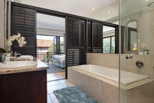 a bathroom with a tub and a sink at 11 Bonabali in Ballito