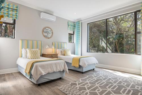 two beds in a room with two windows at 11 Bonabali in Ballito