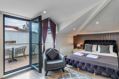 a bedroom with a bed and a chair and a balcony at Etiz Hotels & Residences in Istanbul