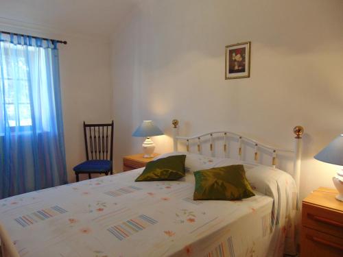a bedroom with a large white bed with two pillows at Casa de Campo em Taipa in Coruche