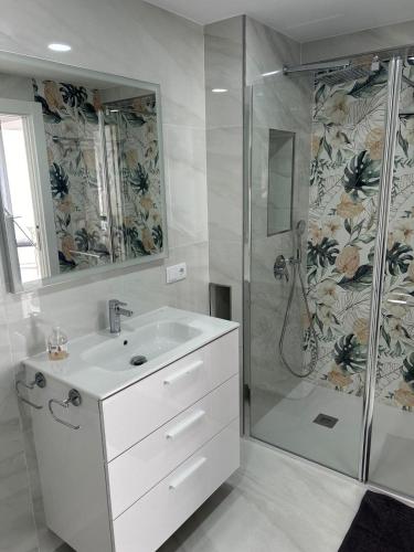a bathroom with a white sink and a shower at Apartamento Blanco Albir in Albir