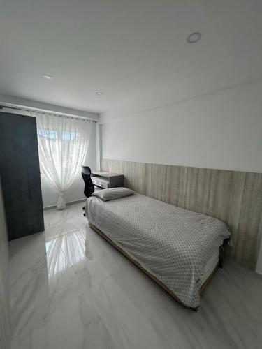 a white bedroom with a bed and a window at Apartamento Blanco Albir in Albir