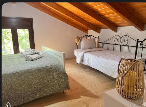 a bedroom with two beds and a window at Chalet Dirfys - Escape in the heart of Evia in Kambiá