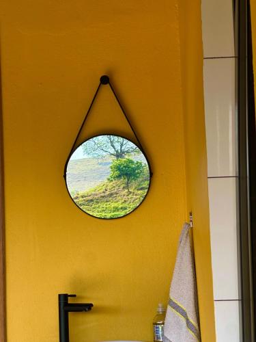 a bathroom with a window on a yellow wall at Recanto do curio in Aparecida