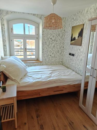 a bedroom with a large bed with a window at 3sine - Ihr besonderer Gasthof im Bahnhof Deisenhofen in Oberhaching