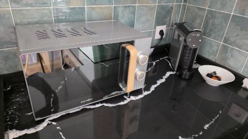 a microwave oven on a counter in a kitchen at Casinhas da Ajuda nº15 in Lisbon