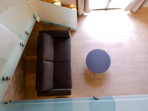 a living room with a black couch and a blue table at Noor Palace - PI Collection Hotel in Palermo