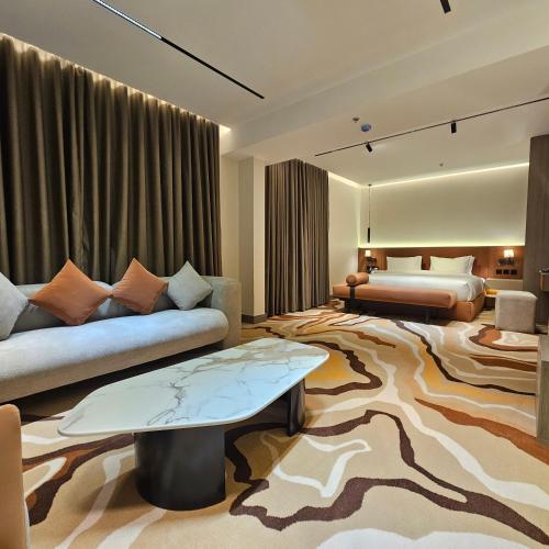 a hotel room with a couch and a bed at Wahed Numas in Hail