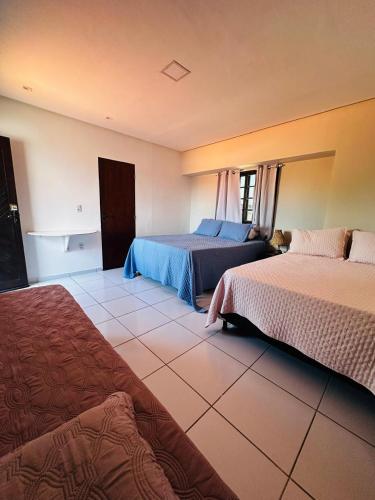 a bedroom with two beds and a tiled floor at CasaMar21- 12 km de Maceió e 10 km FRAN6 in Maceió