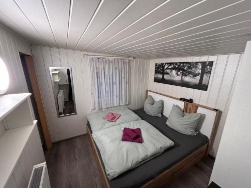 a small bedroom with a bed with two pink pillows at Waldidyll in Plötzky