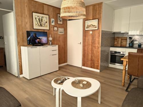 a living room with a table and a kitchen at ZEEWIND Bed by the Sea in Westkapelle