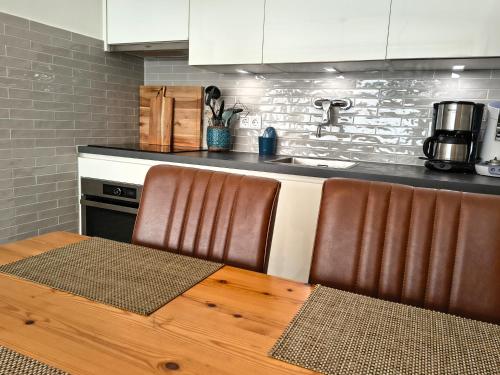 a kitchen with a wooden table with two chairs at ZEEWIND Bed by the Sea in Westkapelle