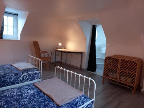 a room with two beds and a table and a table at La petite Tourelle Ruelle de la Fontaine in Péronne