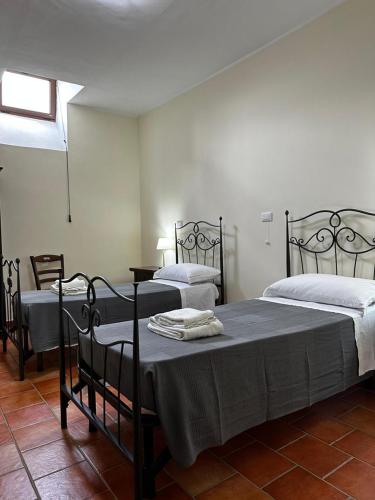 a bedroom with two beds and a window at Locanda Del Castello Bed an Breakfast in San Panfilo dʼOcre