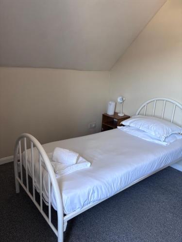 a bedroom with a large bed with white sheets and pillows at Dover Priory Hotel in Dover