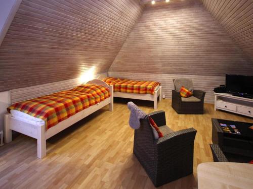 a room with a bed and chairs in a attic at Ferienwohnung in Westerland auf Sylt in Westerland