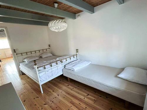 a bedroom with two beds and a chandelier at 4 star holiday home in SÖLVESBORG in Sölvesborg