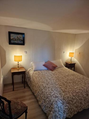 a bedroom with a bed with two tables and two lamps at domaine des trois rivières in Sainte-Marguerite-de-Viette