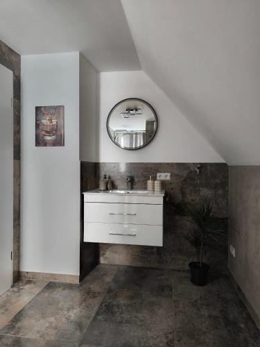 a bathroom with a white sink and a mirror at Ferienwohnung Kampić Hirsch & Heimat in Rottweil