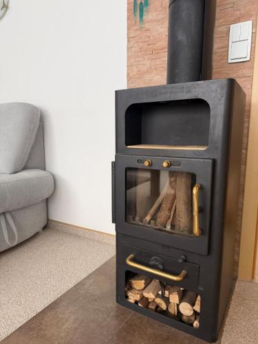 a black stove with logs in a living room at Haus Ostseewind in Zingst