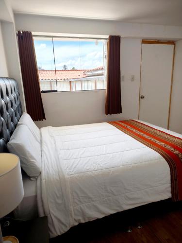 a bedroom with a large bed and a window at Hostal Cusco de mis Sueños in Cusco