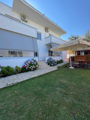 una casa con un patio e un ombrellone di Central Garden Sofia Studios a Ksamil