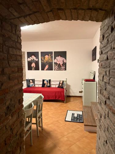 a living room with a red bed and a table at Residenza Il Castello Tre in CastellʼArquato