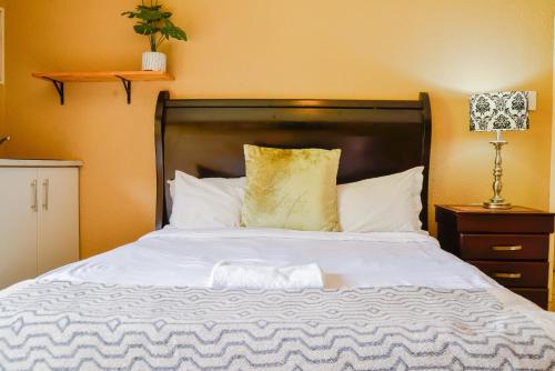 a bedroom with a large bed with white sheets at Cozy guestrooms in Midrand in Midrand