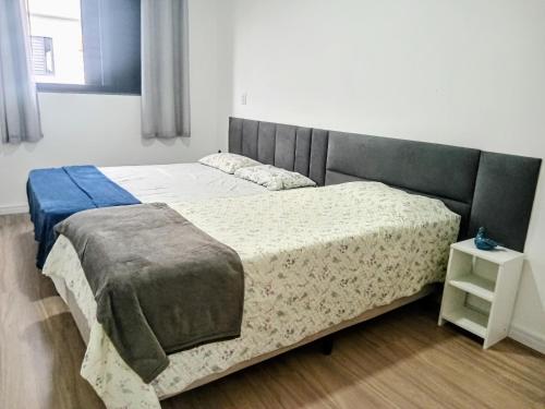 a bedroom with two beds and a night stand at Casa das Cachoeiras in Botucatu