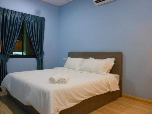 - une chambre avec un lit et 2 serviettes dans l'établissement Eiman Homestay, Kluang, à Keluang