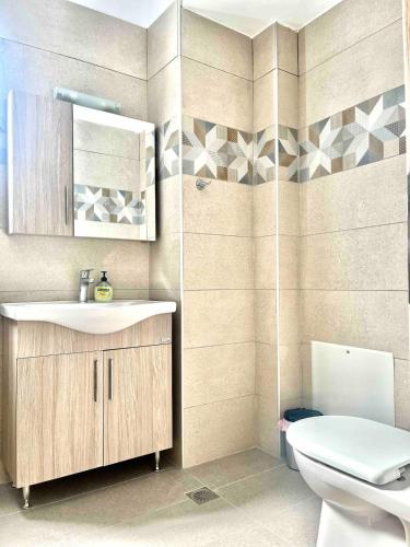 a bathroom with a sink and a toilet at Nóstos Home in Kos