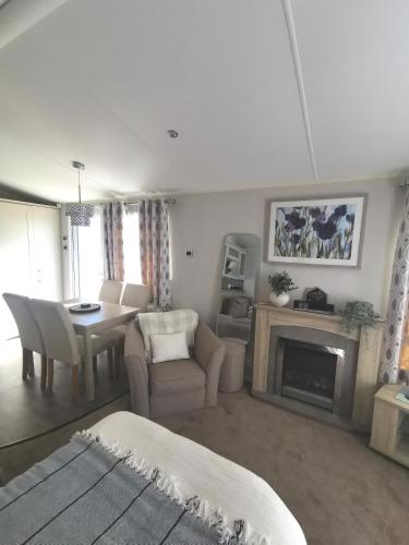 a living room with a table and a fireplace at Washbrook Way 2 in Fenny Bentley