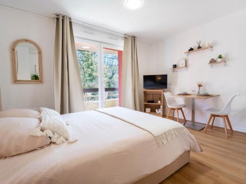 a white bedroom with a bed and a desk and a window at Le doux refuge domaine thermal et activités touristiques Amnéville in Amnéville