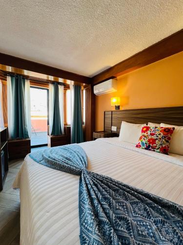 a bedroom with a large bed with blue curtains at Suites del Jardín Principal in Guanajuato