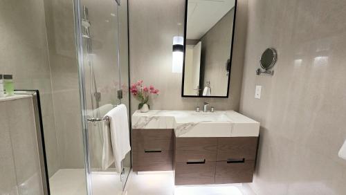 a bathroom with a sink and a mirror and a shower at Three Bedrooms Apartment at Address Residence Fujairah by Solo Realty in Fujairah