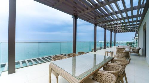 a dining room with a glass table and chairs at Three Bedrooms Apartment at Address Residence Fujairah by Solo Realty in Fujairah