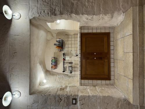a bathroom with a stone wall with a wooden door at More Apartments il castello in Bari