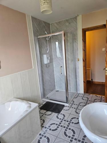 a bathroom with a shower and a tub and a sink at Orchard Cottage in Loughgall
