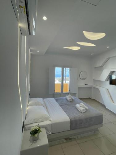 a bedroom with a bed with two towels on it at Fira centerline Prestige suites in Fira